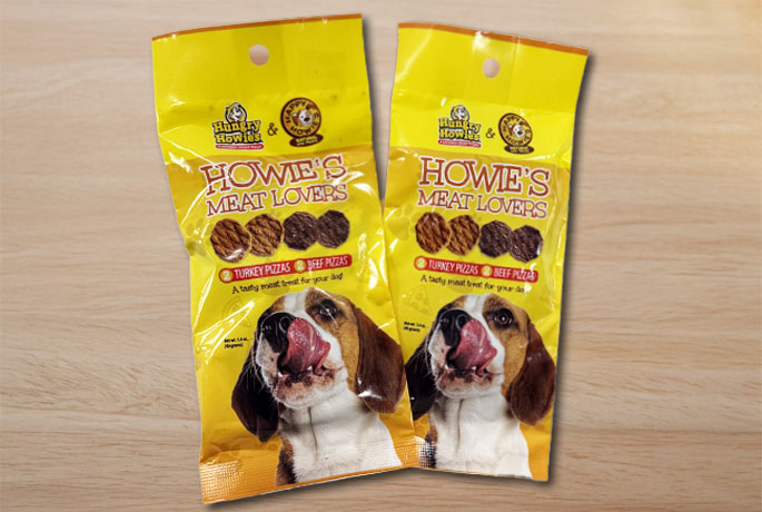 Two yellow bags of Happy Howie's dog treats with a dog locking it's mouth.