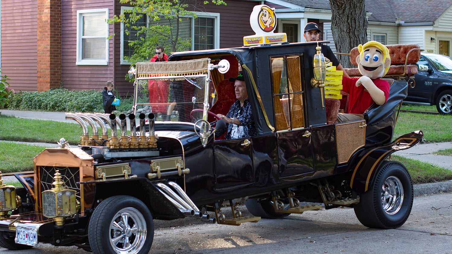 man driving car with hungry howies mascot