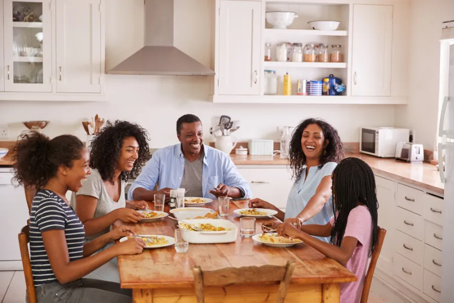 Family enjoying baked pasta and pizza for dinner