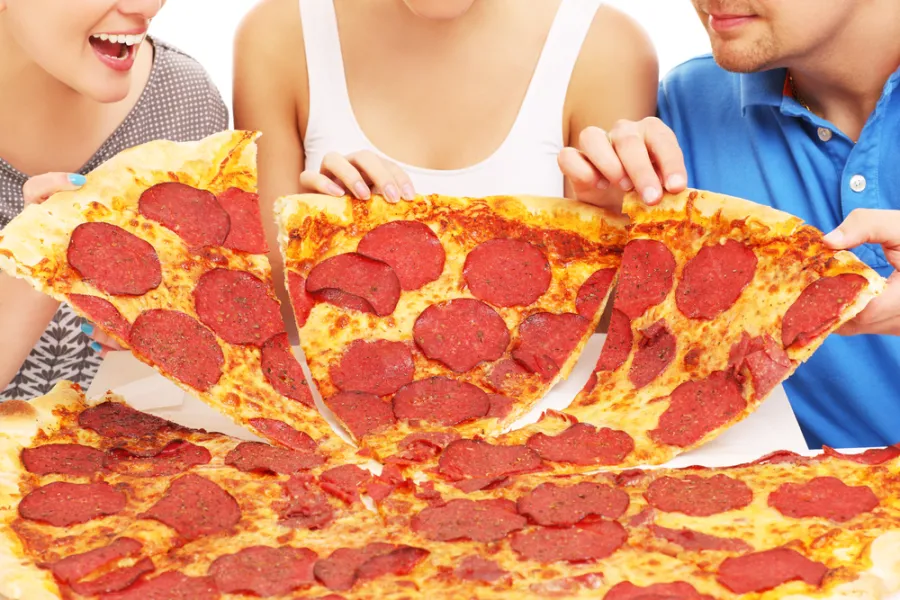 A family enjoying a large slices of Hungry Howie's pizza