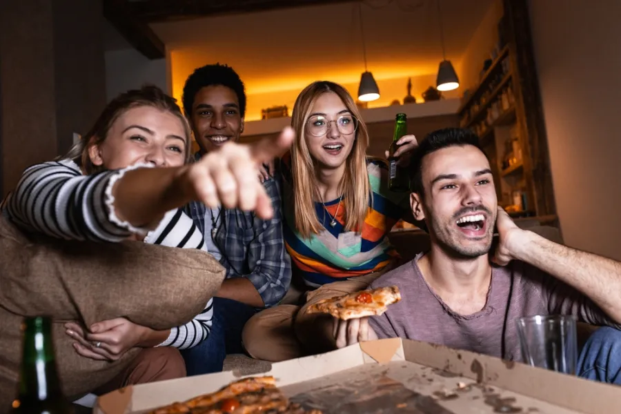 Group of friends enjoying pizza and watching a movie